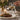 A video of Steak with vegetables being drizzled with sauce, set on a table with a glass of wine and flowers.